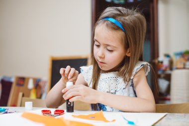 Küçük kız aplike evde ödev olarak yapıyor