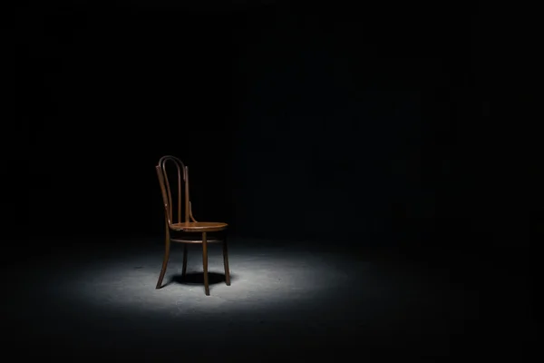 孤独的椅子上坐下，空荡荡的房间 免版税图库照片