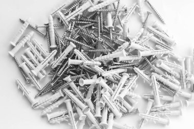 Beyaz arka plana saçılmış çapayı vidalayın. Tamir için plastik tıkaçlar.