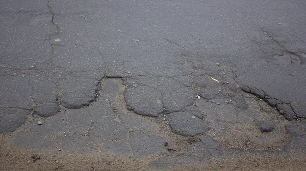 Mala carretera, baches en el asfalto, reparaciones en la carretera . —  Fotos de Stock