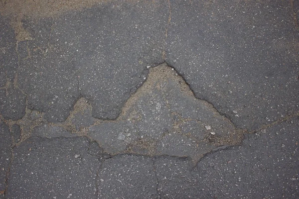 Špatná cesta, poškozený asfalt, rozmazané výmoly na trati. — Stock fotografie