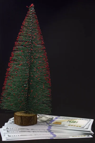 Різдвяна ялинка і 100 купюр на чорному тлі. Концепція подарунка під ялинкою . — стокове фото