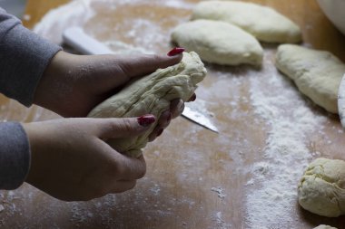 Turta yapan bir kadının elinde bir parça hamur. Elma dolması dilimli çörekler pişirmek için hazırlar..