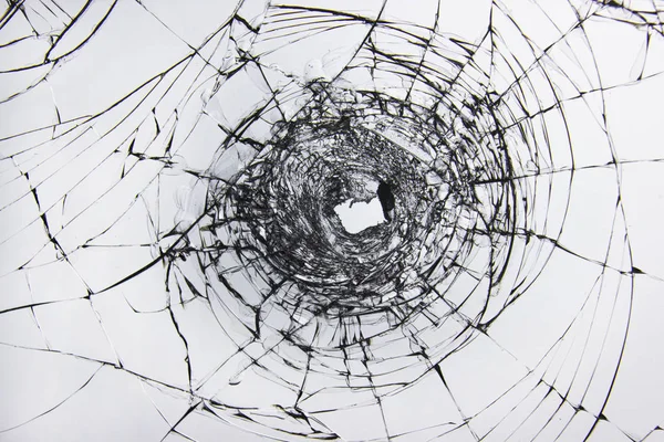 Μια τρύπα και ρωγμές σε σπασμένα γυαλιά σε ένα παράθυρο από υαλοπίνακα αυτοκινήτου. — Φωτογραφία Αρχείου