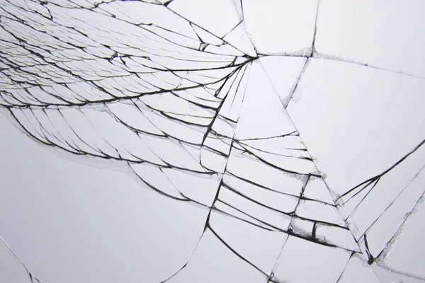 Sprucken krossat glas i fönstret på ljusgrå bakgrund. Sprickor koncept för design. — Stockfoto
