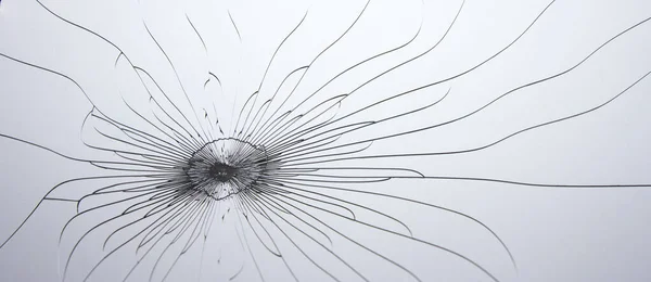 Krossat glas. Linjer och sprickor på en grå bakgrund. — Stockfoto