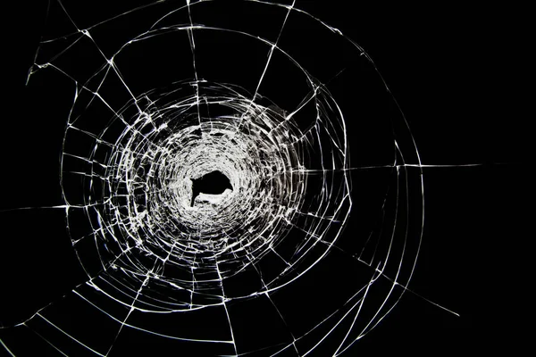 Hole and cracks on the glass from a shot from a weapon — Stock Photo, Image