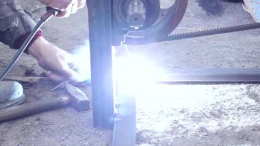 Metal yapıların elektroplazması. İşçi metali ve metal çubuğu onları korumak için kaynak yapıyor. Elektrik kaynaklarından kıvılcımlar ve parıltılar.