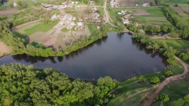 湖を渡って小さな村の家に飛ぶ — ストック動画