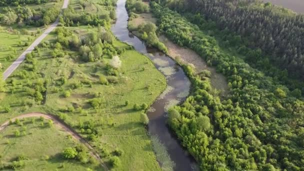 Paysage de la rivière qui s'étend à travers la vallée, le soleil du soir et l'herbe verte 