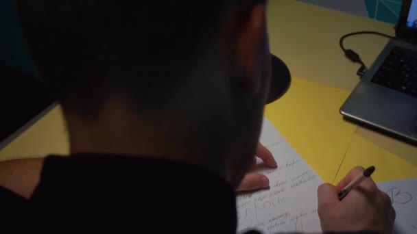De aproape. Tipul scrie pe o bucată de hârtie cu un stilou, dorește, comandă cadouri — Videoclip de stoc