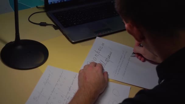 Primer plano. El tipo muestra cuidadosamente las letras en un pedazo de papel en una carta — Vídeos de Stock