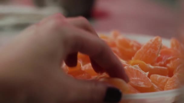 Zbliżenie. Dziewczyny ręka bierze kawałek mandarynki z talerza na imprezie — Wideo stockowe