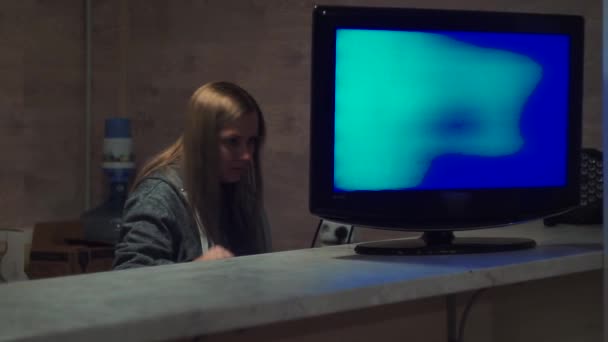 Das Mädchen hinter dem Bildschirm mit Drähten versucht, einen schwarzen Fernseher anzuschließen — Stockvideo
