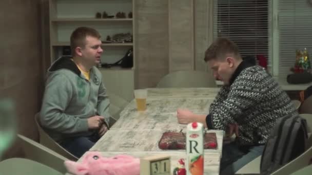 Guys are sitting table, joking, laughing, talking, looking an imaginary clock. — Stockvideo