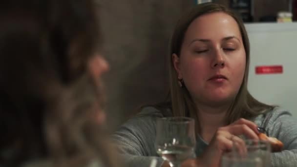 Girl dancing with food in her hands while sitting at the bar at a party — Stock Video