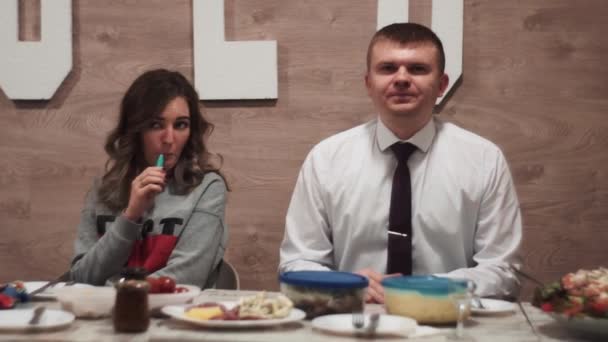 Nerd in suit with tie and fashionable, stylish, smoking girl the festive table — Stock Video