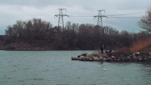 Pescador na cidade, definir varas de pesca, à espera de uma captura, mordiscar no rio — Vídeo de Stock