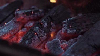 Hot coals, firewood in the brazier are inflated with air, the flame intensifies, sparks go