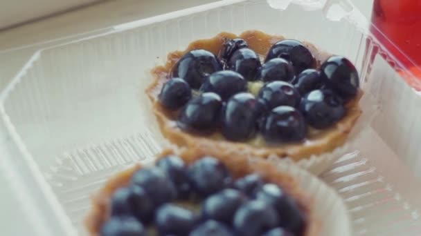 Hermosas y deliciosas tartaletas de pastelería, magdalenas con grandes arándanos azules, frutas — Vídeo de stock