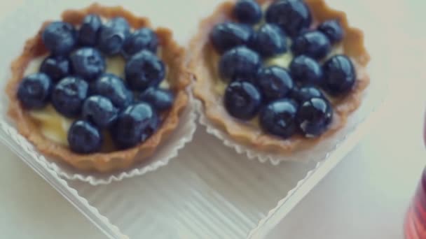 Hermosas y deliciosas tartaletas de pastelería, magdalenas con grandes arándanos azules, frutas — Vídeo de stock