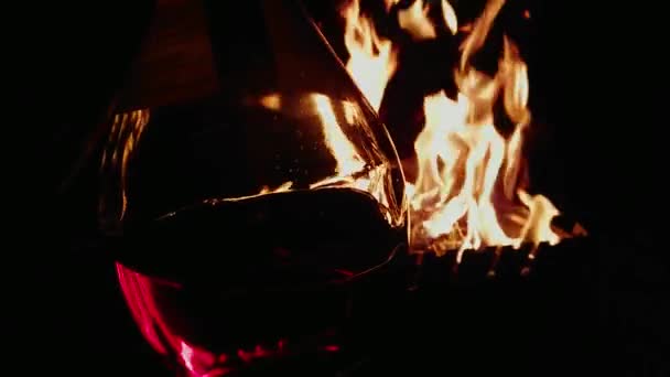 Une grande bouteille de vin sur fond de feu, en vacances, la nuit, un pique-nique — Video