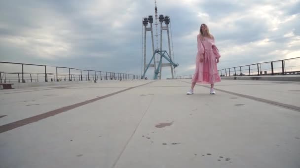 ドレスの女の子は橋の地下で踊ろうとしています — ストック動画
