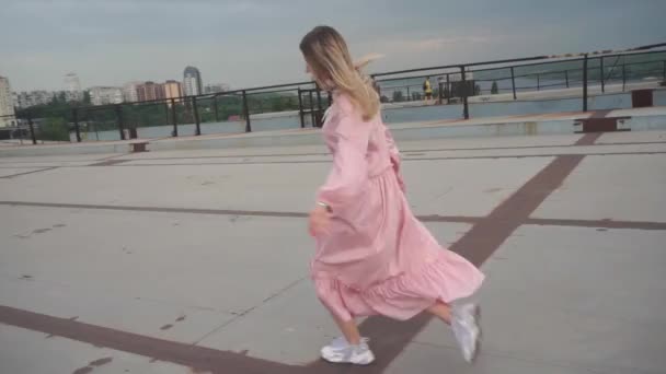 Dívka, na útěku tančí, pohybuje se, skáká, točí se kolem sebe. Pozadí města — Stock video