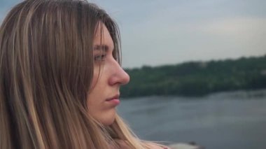 Üzgün şirin kız ufukta, şehrin manzarasına bakıyor. Kötü yüz derisi. Gökyüzü bulutlu