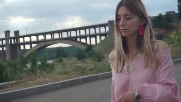 Dziewczyna z toousled włosy toousled spacery samotnie wzdłuż opuszczonej drogi — Wideo stockowe