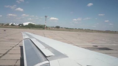 Uçağı kanatlandırır, pistte hızlanır, tarlaların arka planına tırmanır.