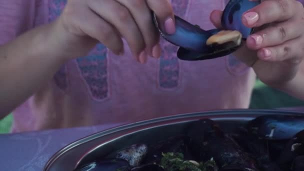 Elégedett lány eszik kagyló kéthéjú kagyló nyaralás közben. Közelkép — Stock videók