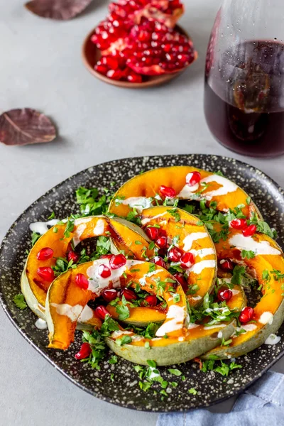 Grilled pumpkin with pomegranate and white sauce. Healthy eating.