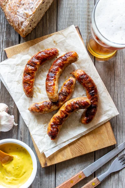 Grilled sausages with mustard and beer. German cuisine.