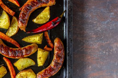 Patates, havuç ve biberli ızgara sosis. Alman mutfağı..