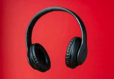 Kırmızı arka planda siyah kulaklıklar. Asgari konsept.