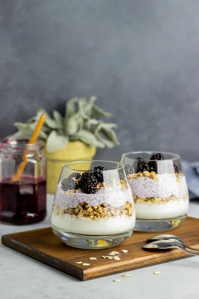 Gri arka planda yoğurt, chia tohumu ve böğürtlen. Kahvaltıda. Sağlıklı beslenme.