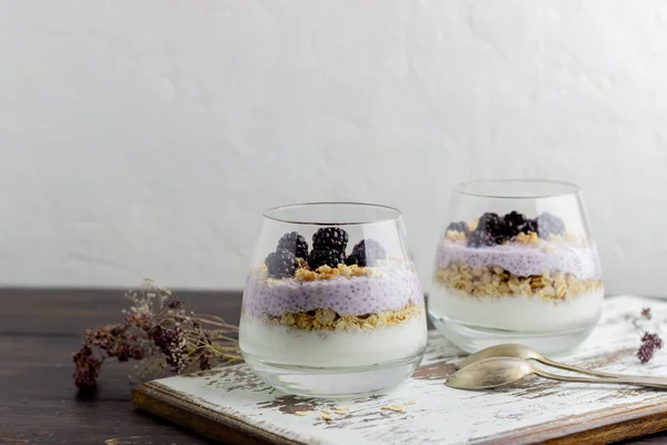 Yoghurt med granola, chiafrön och björnbär på en träbakgrund. Frukost. Hälsosam kost. — Stockfoto