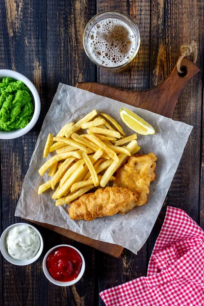 Fish and chips on a wooden background. British fast food. Recipes. Snack to beer. English cuisine.