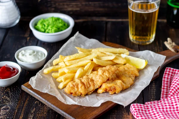 Fish and chips on a wooden background. British fast food. Recipes. Snack to beer. English cuisine.