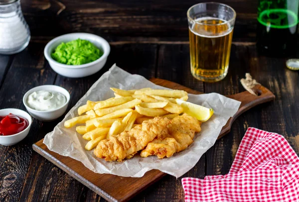 Ahşap zeminde balık ve patates kızartması. İngiliz fast food. Yemek tarifleri. Atıştırmalıktan biraya. İngiliz mutfağı.