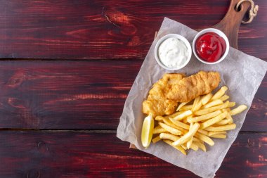 Ahşap zeminde balık ve patates kızartması. İngiliz fast food. Yemek tarifleri. Atıştırmalıktan biraya. İngiliz mutfağı.