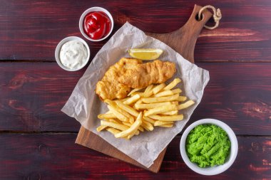 Ahşap zeminde balık ve patates kızartması. İngiliz fast food. Yemek tarifleri. Atıştırmalıktan biraya. İngiliz mutfağı.