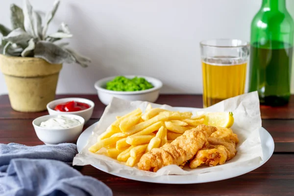 Fish and chips on a wooden background. British fast food. Recipes. Snack to beer. English cuisine.