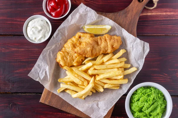 Ahşap zeminde balık ve patates kızartması. İngiliz fast food. Yemek tarifleri. Atıştırmalıktan biraya. İngiliz mutfağı.