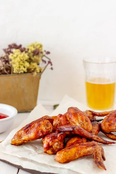 Grilled chicken wings with beer and red sauce on a wooden background. Snack to beer. Barbecue. Recipes. — Stock Photo, Image