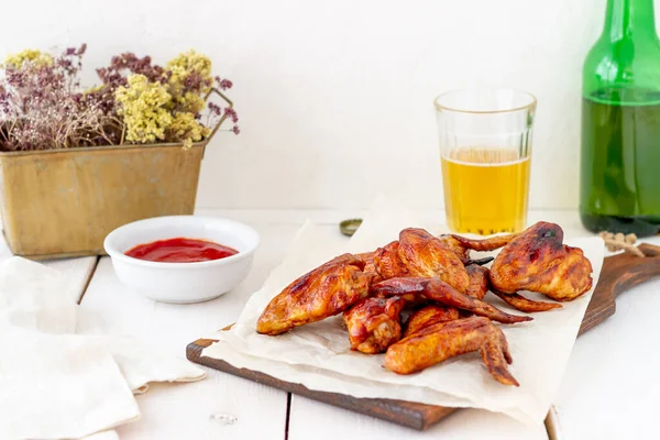 Alitas de pollo a la parrilla con cerveza y salsa roja sobre un fondo de madera. Snack a cerveza. Barbacoa. Recetas . — Foto de Stock