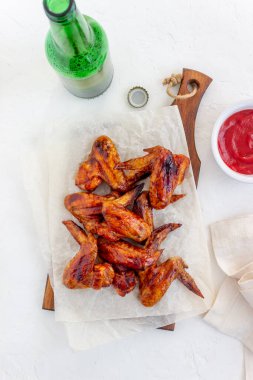 Beyaz arka planda ızgara tavuk kanadı ve bira. Atıştırmalıktan biraya. Barbekü. Tarifler.