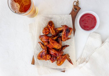 Beyaz arka planda ızgara tavuk kanadı ve bira. Atıştırmalıktan biraya. Barbekü. Tarifler.