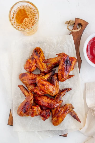 Grilled chicken wings and beer on a white background. Snack to beer. Barbecue. Recipes.